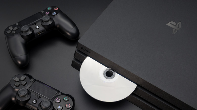 PS4 Pro with disc inserted and two DualShock controllers