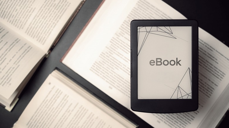 Books on a table and an e-reader displaying "eBook"