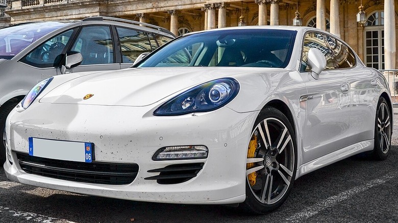 White Porsche Panamera Diesel parked in front of opulent building