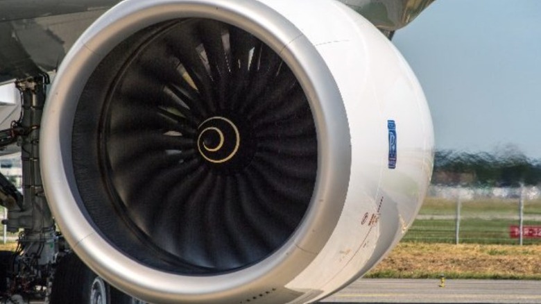 Engine attached to an aircraft with black fans and white outer body