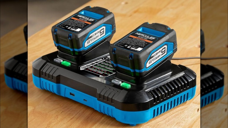 A Hercules charger on a wooden tabletop charging two batteries