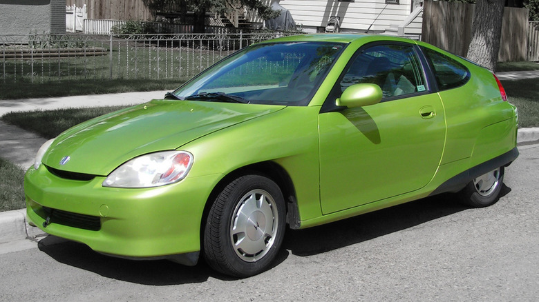 Lime green first-generation Honda Insight seen from left front parked at a curb