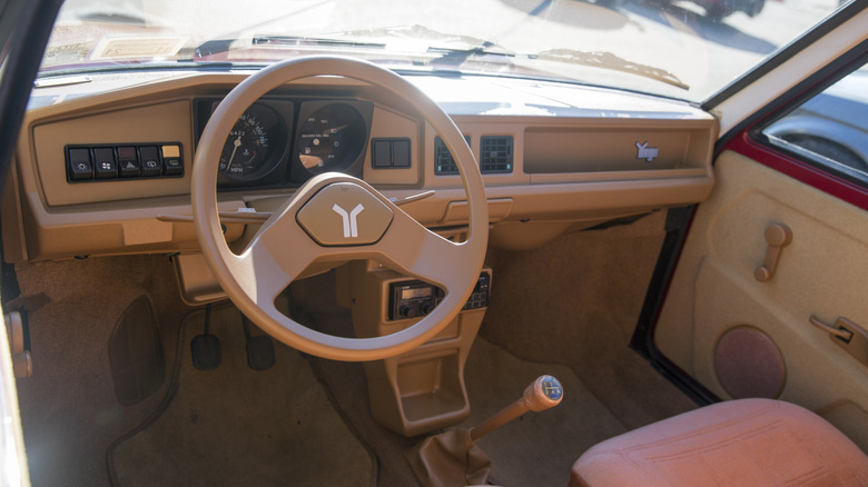 The Yugo's interior, driver's side, cream upholstery and panels
