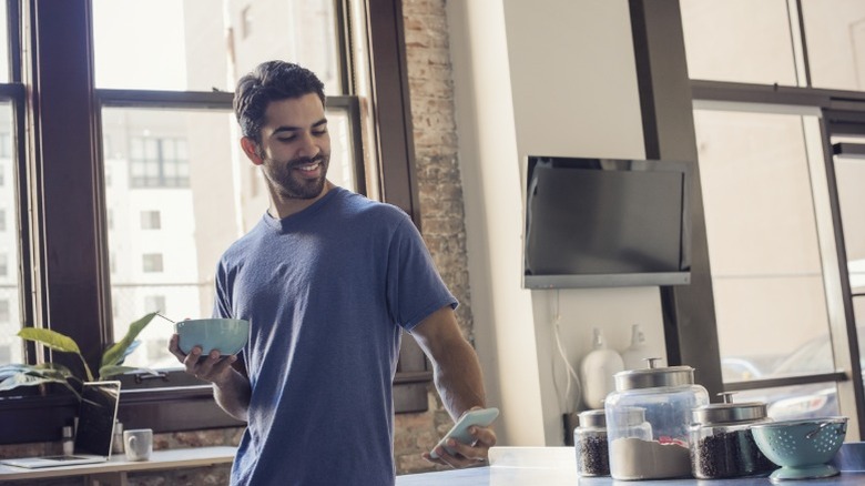 A man in a kitchen with a TV