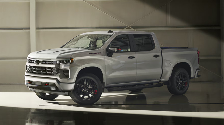 Silver 2026 Chevy Silverado 1500 pickup parked indoors with light shining on it