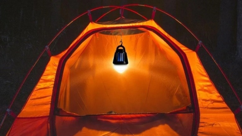 Orange tent illuminated by a hanging lantern