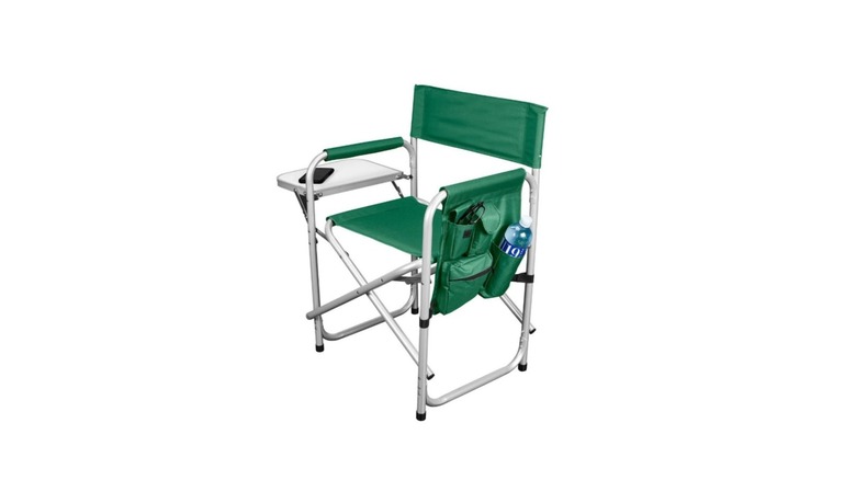 Green folding chair with attached table on grass