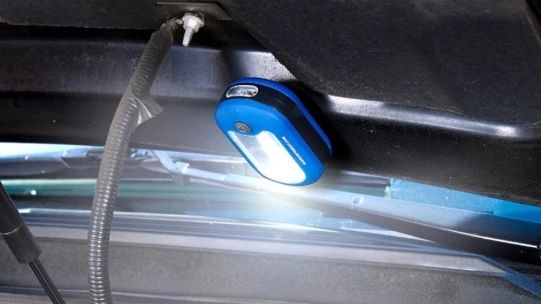 LED light attached to the open hood of a car