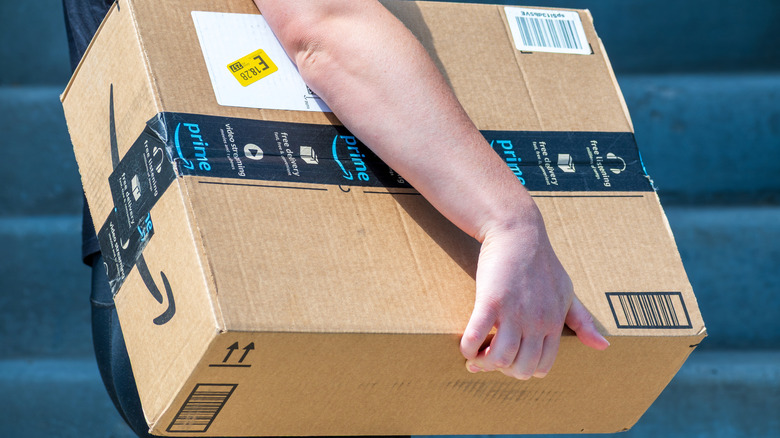 Someone carrying a big Amazon box.