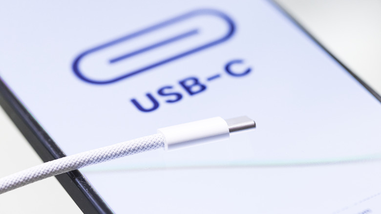Close-up of a USB-C cable with a 'USB-C' sign in the background.