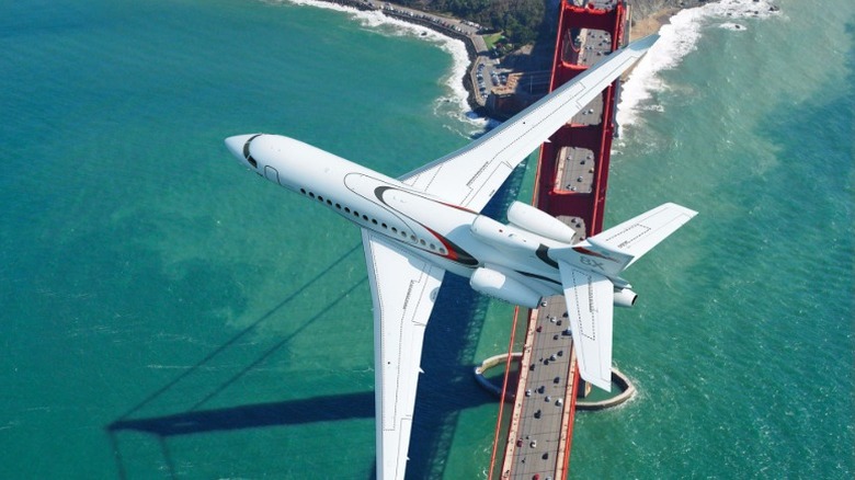 A Dassault Falcon 8X flying over a bridge