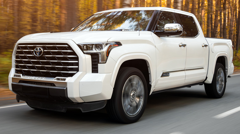 A white Toyota Tundra driving on a road
