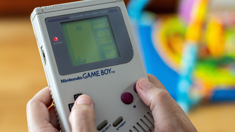 Someone playing Tetris on an old Game Boy.