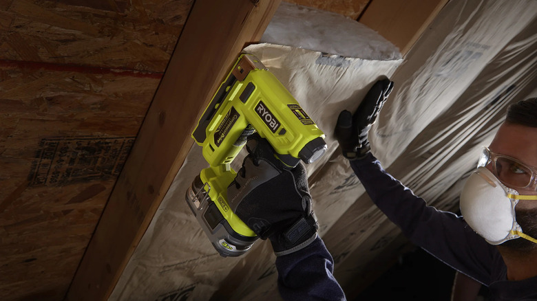 Crown Stapler being used to put in insulation in-between wood frames.