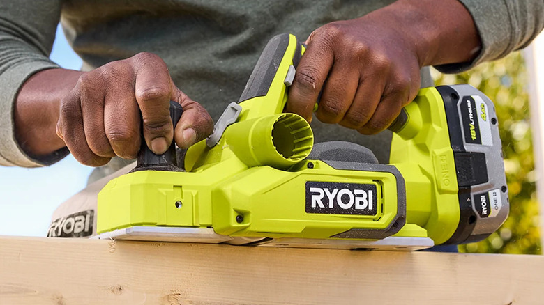 Ryobi Hand Planer being used to cut along the top of lumber