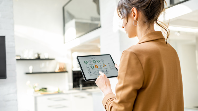 woman controlling smarthome with tablet