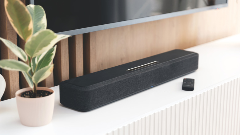 soundbar with remote on a stand below tv
