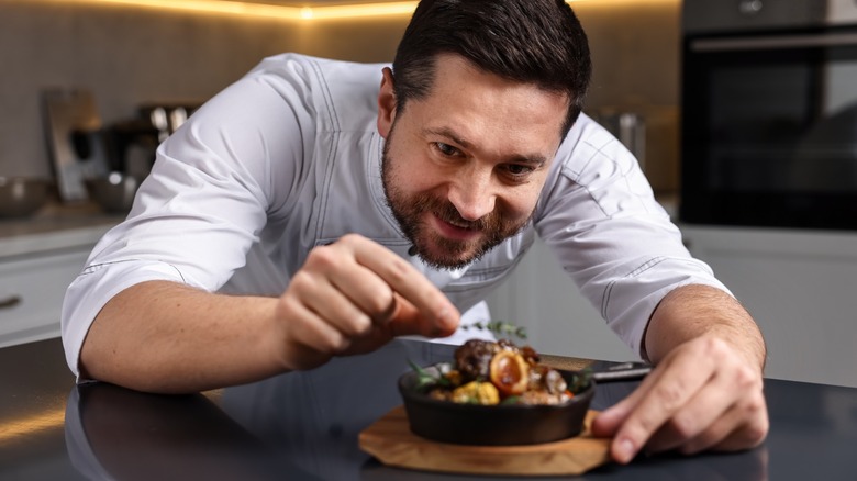 A chef putting finishing touches on a dish