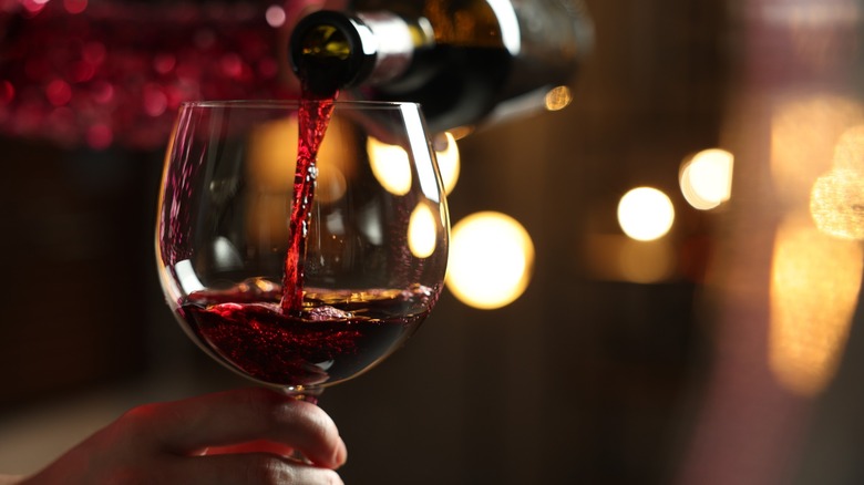 a wine glass getting filled with red wine