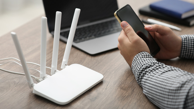 man with smartphone and router