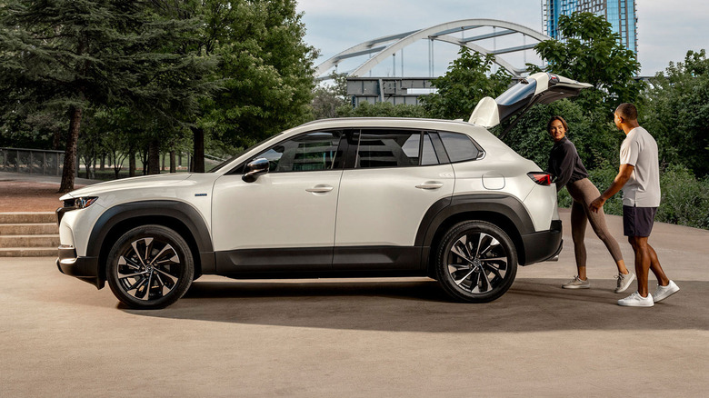 Owners putting luggage into a CX-50