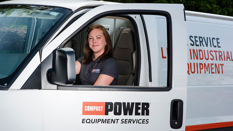 A woman driving a Compact Power Equipment van