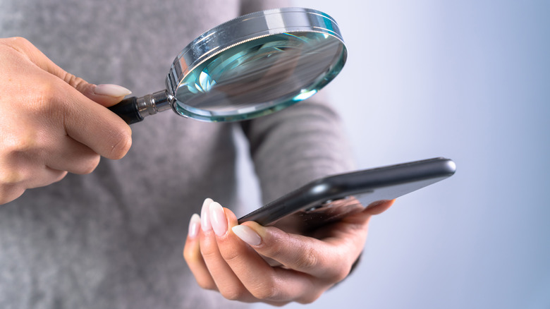 Woman in orange shirt holding magnifying glass