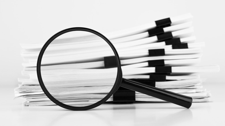 stack of documents with magnifying glass