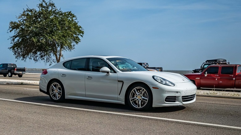 A white first generation Porsche Panamera on the highway, front 3/4 view