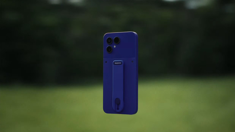 A blue Fairphone Gen 6+ rendered here in mid air with a bokeh outside background, equipped with the optional hand strap on the back.
