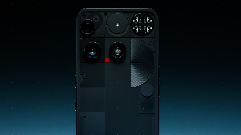 The back of a black Nothing Phone 3 rendered here against a deep blue background with silver dots visible too.