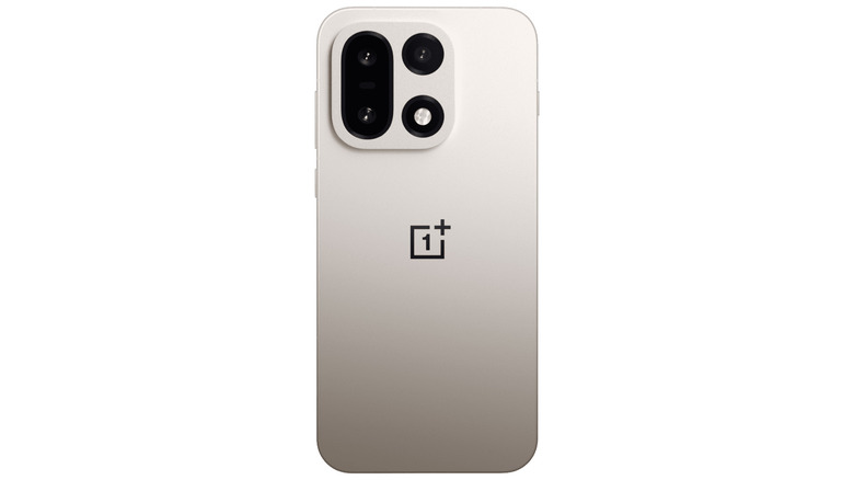 A cream metallic OnePlus 15 phone on a white studio background, back of the phone visible.