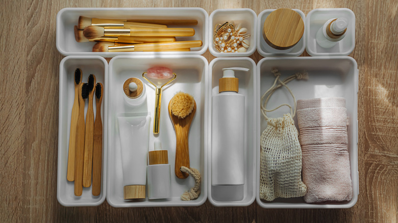 Bathroom toiletries arranged in several small square and rectangular containers