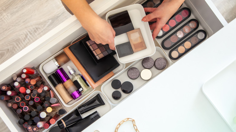 Makeup products neatly packed in drawer as seen from above