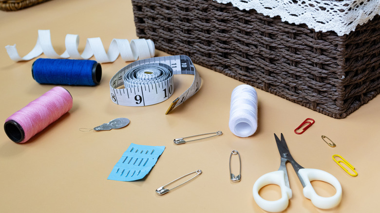 Closeup of sewing accessories next to a small basket