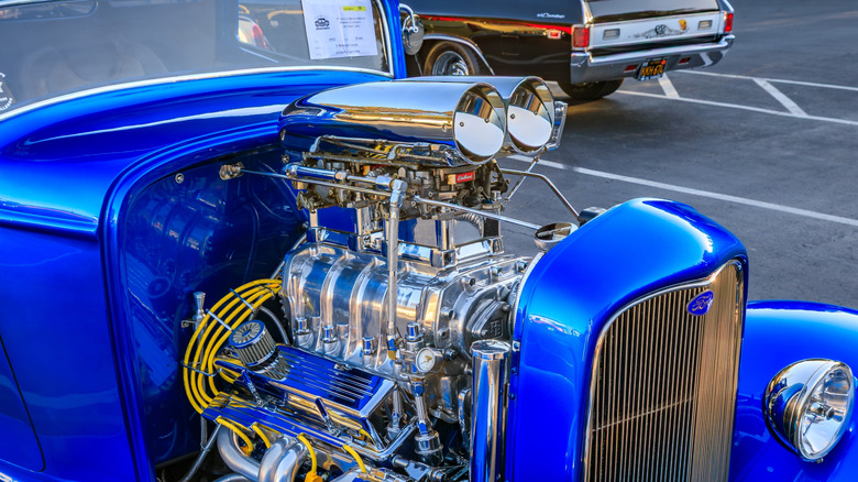 blue hot rod with supercharger in parking lot