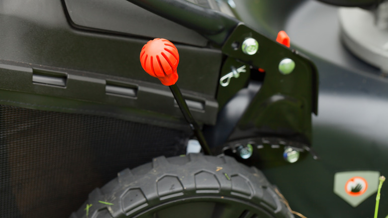 closeup of a height adjustment lever on lawn mower
