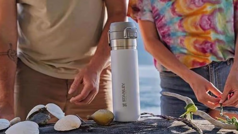 people standing outside with a Stanley vacuum bottle