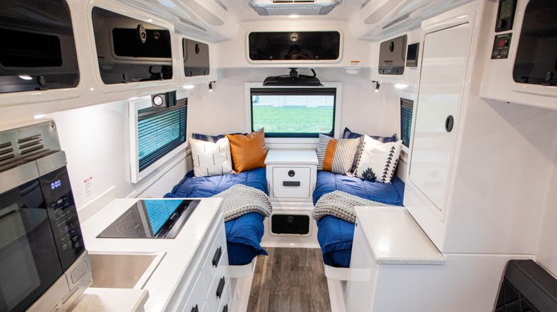Interior of an Oliver Apex X23 travel trailer showing the beds and dining area
