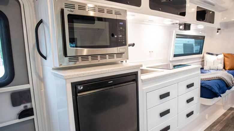 Interior of Oliver Apex X23 travel trailer showing the entry door, microwave, and countertop area
