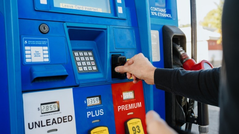 a man using a credit card to pay for gas