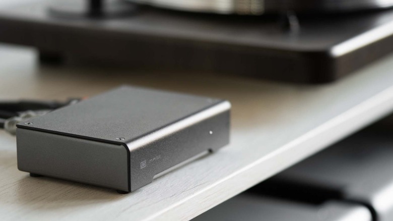 Shallow-focus photo of Schiit Mani 2 next to a turntable.