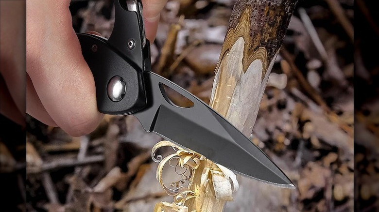 Ripping a thin piece of wood using a sharp knife.