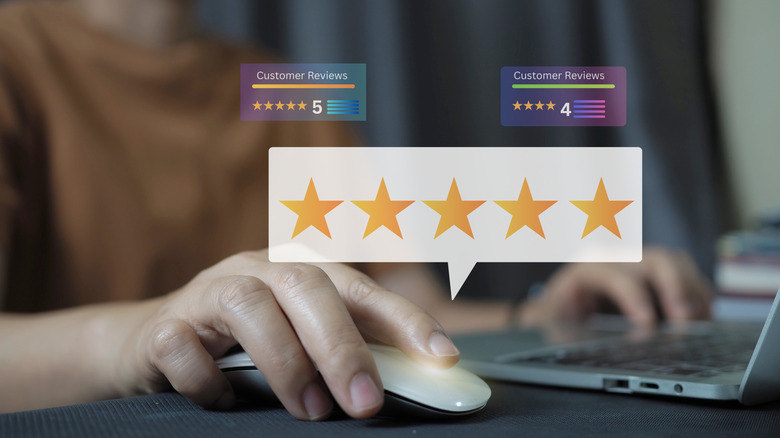 Holographic image of a five star rating above a mouse and a laptop.