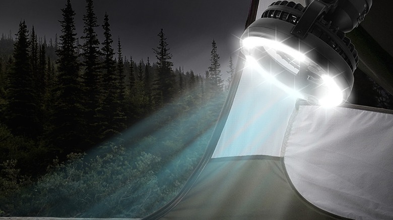 A ceiling-mounted lantern lighting up a camping tent.