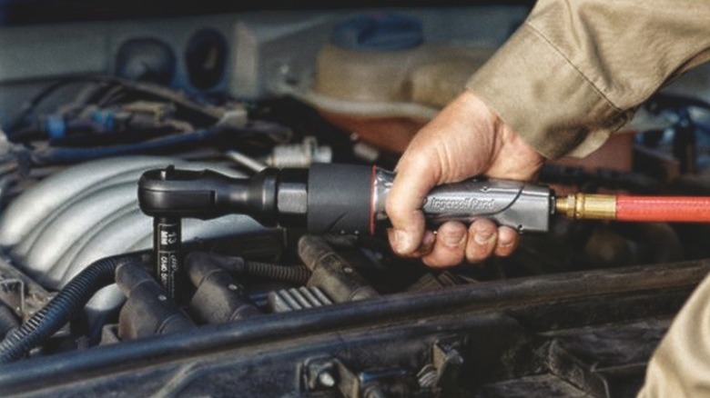 person using pneumatic ratchet wrench