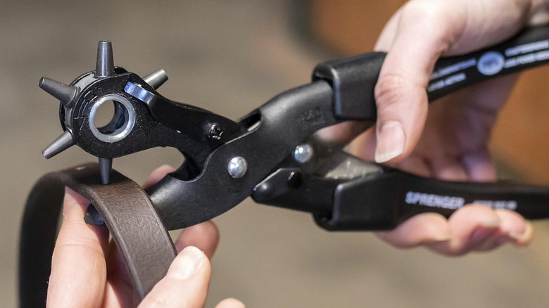 The Herm Sprenger leather hole punch creating a hole into a piece of leather