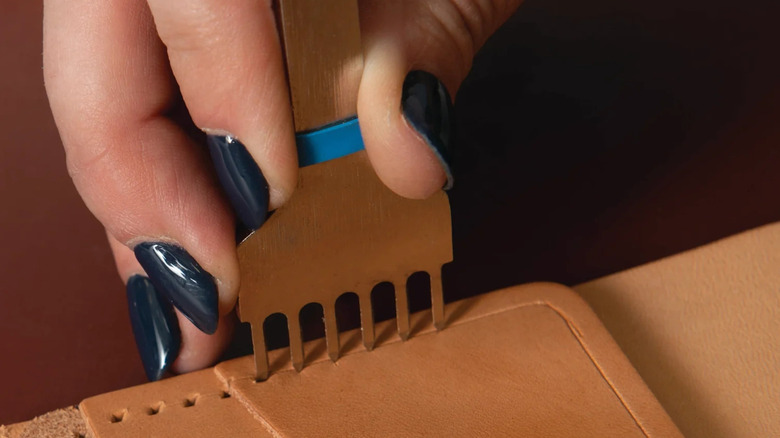 Diamond chisel set being used to create holes in leather