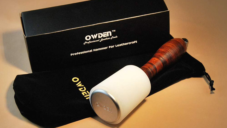 The Owden leather carving mallet next to its opening box and leather wrap