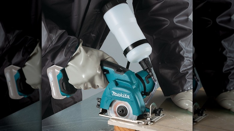 Cutting a piece of tile using Makita saw.
